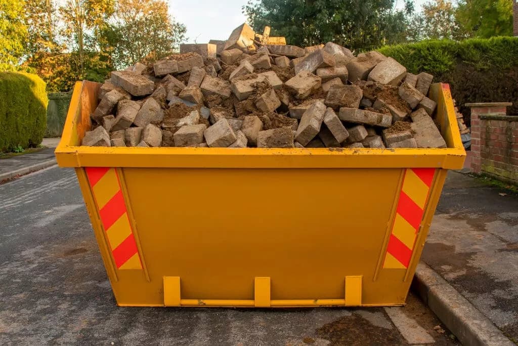 Benne à gravats en cours de remplissage sur chantier de rénovation à Gémozac