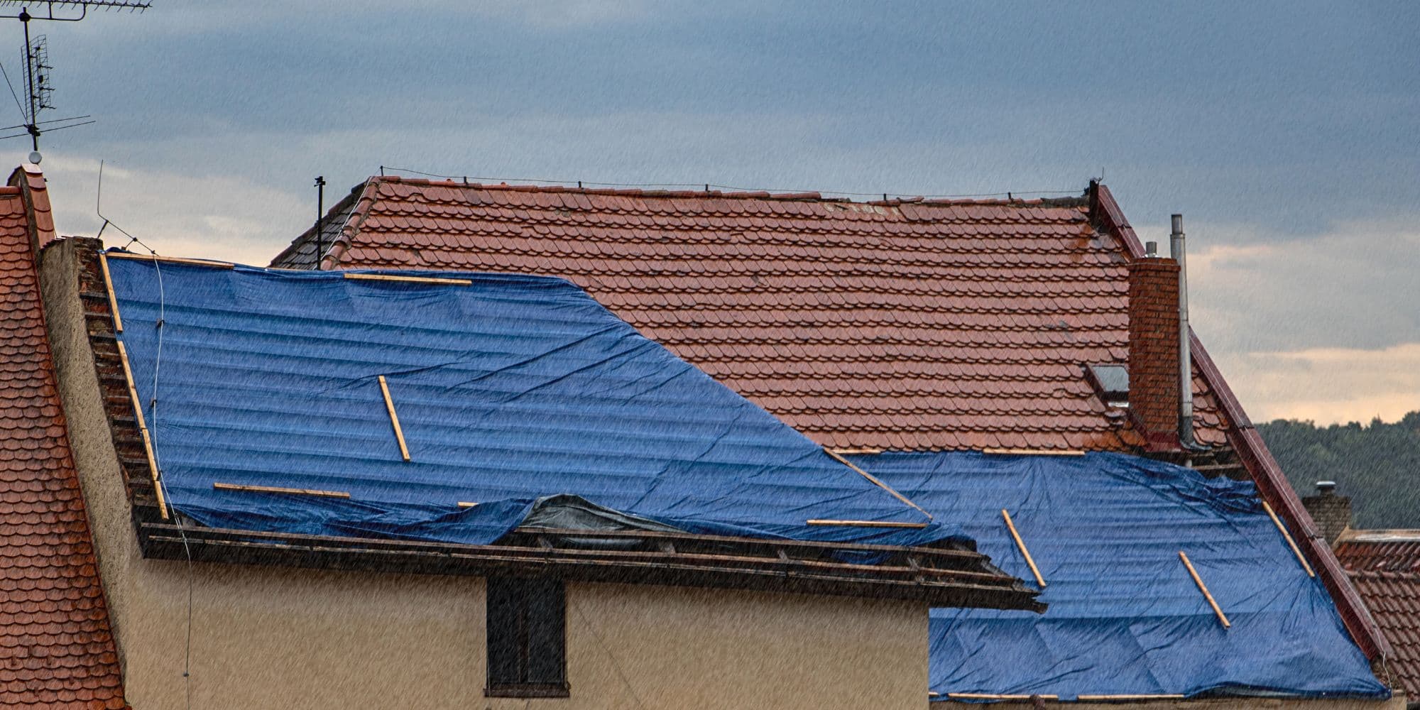 Couvreur réalisant un bâchage d'urgence après tempête à Izon